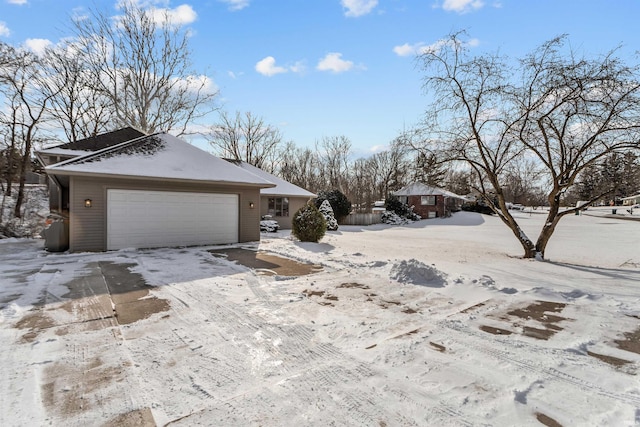 view of snowy exterior with a garage