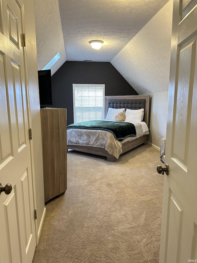 carpeted bedroom with baseboards, vaulted ceiling, and a textured ceiling