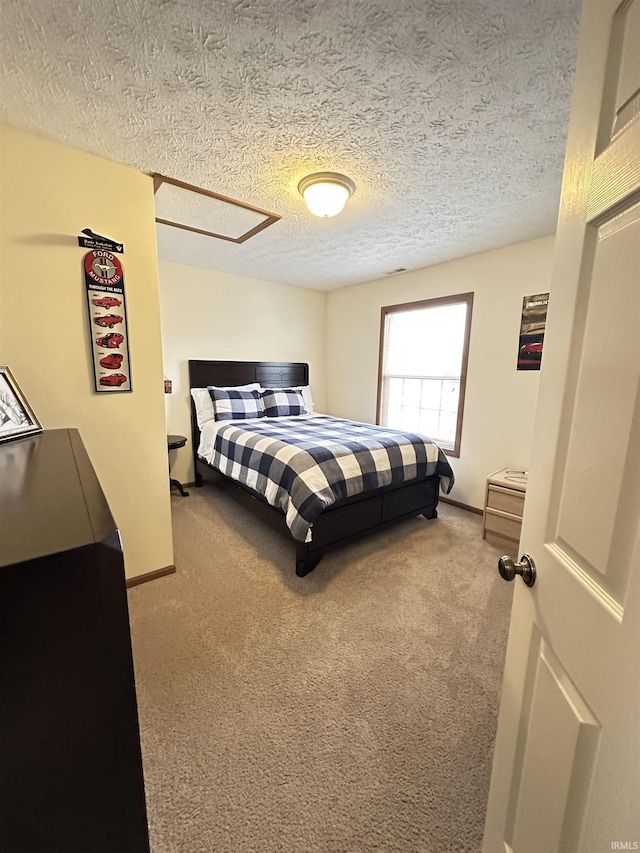 carpeted bedroom with a textured ceiling and baseboards