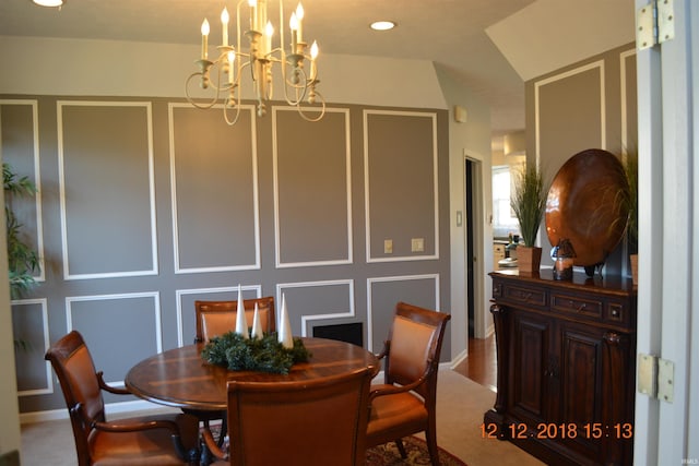 dining area with a decorative wall, a notable chandelier, and recessed lighting