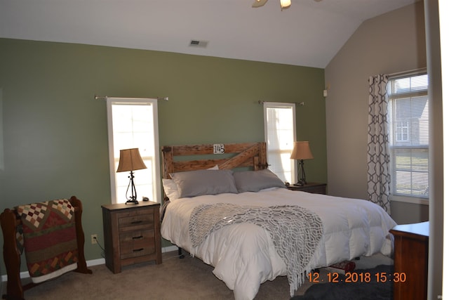 bedroom with carpet floors, lofted ceiling, and visible vents