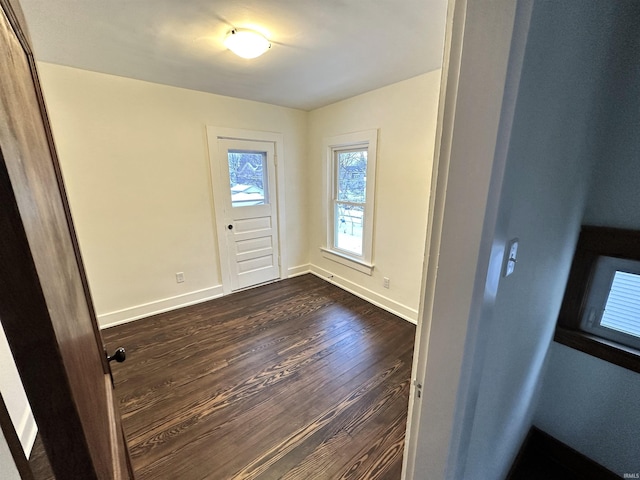 foyer entrance featuring baseboards and dark wood-type flooring