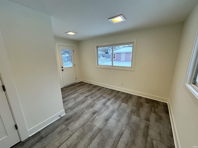 spare room featuring wood finished floors and baseboards