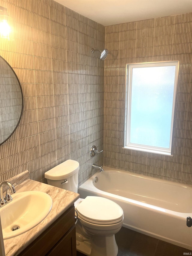 full bath featuring vanity,  shower combination, toilet, and tile walls