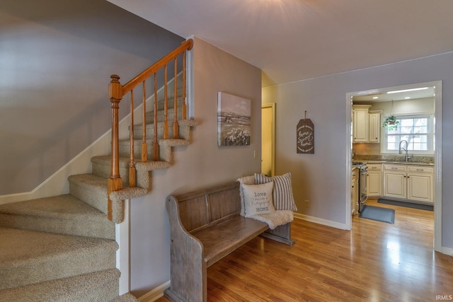 stairs featuring sink and wood-type flooring