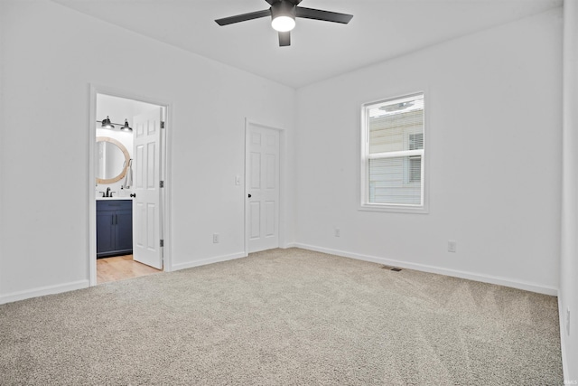 unfurnished bedroom with light colored carpet and ensuite bath