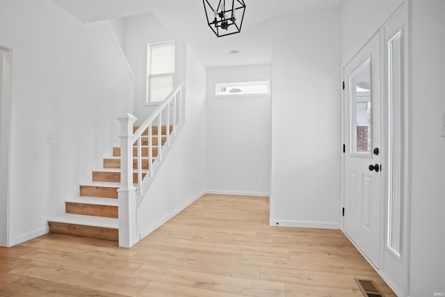 foyer featuring an inviting chandelier and light hardwood / wood-style flooring