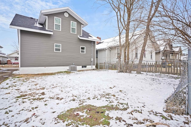 snow covered rear of property with central AC