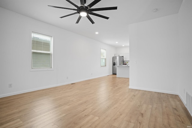 unfurnished living room with ceiling fan and light hardwood / wood-style floors