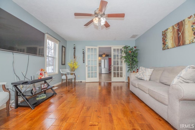 living room with ceiling fan, wood-type flooring, and french doors