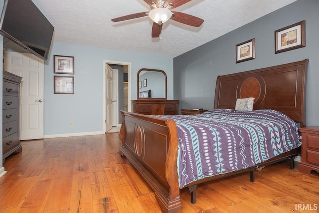 bedroom featuring hardwood / wood-style flooring, ceiling fan, and a textured ceiling