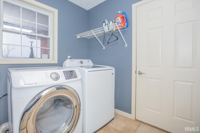laundry room with washer and dryer and light tile patterned floors