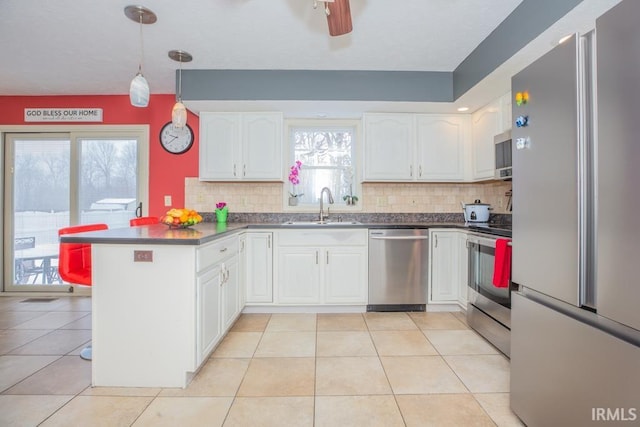 kitchen featuring sink, kitchen peninsula, white cabinets, and stainless steel appliances