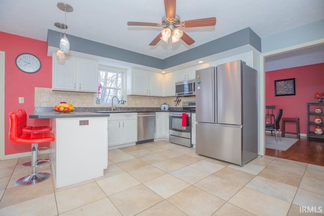 kitchen featuring appliances with stainless steel finishes, kitchen peninsula, a breakfast bar area, and white cabinets