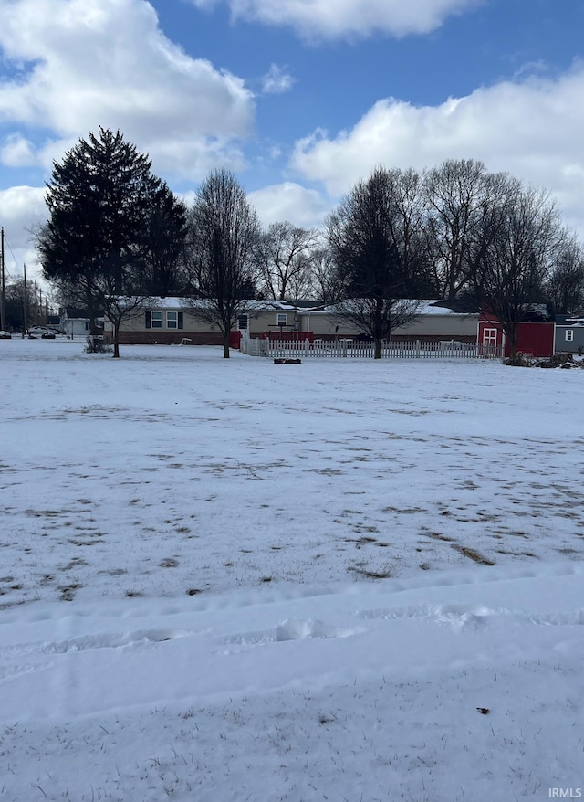 yard covered in snow with a storage shed