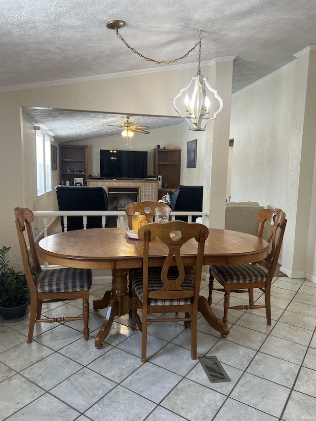 dining room featuring a textured ceiling, a textured wall, ornamental molding, and light tile patterned flooring