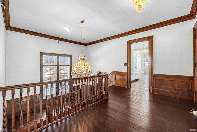 corridor with ornamental molding, a chandelier, and dark hardwood / wood-style flooring