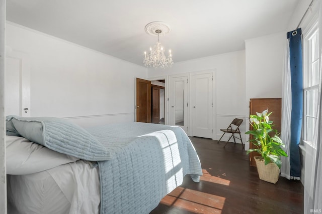 bedroom with dark wood-type flooring and a notable chandelier