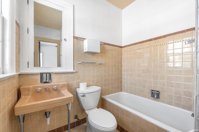 bathroom with tile walls, toilet, and tiled bath