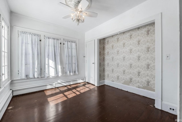 empty room featuring dark wood-type flooring, ceiling fan, and baseboard heating