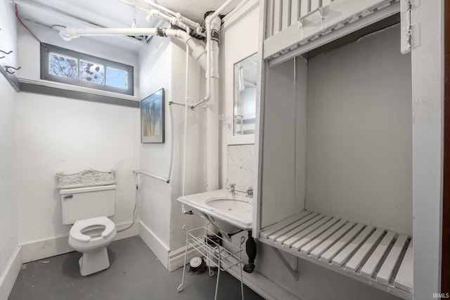 bathroom with concrete flooring and toilet