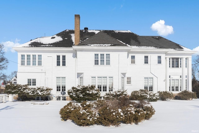 view of snow covered back of property