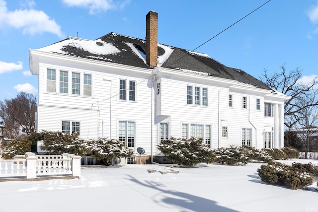 view of snow covered rear of property