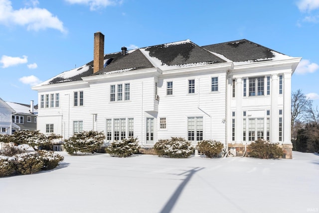 view of snow covered back of property