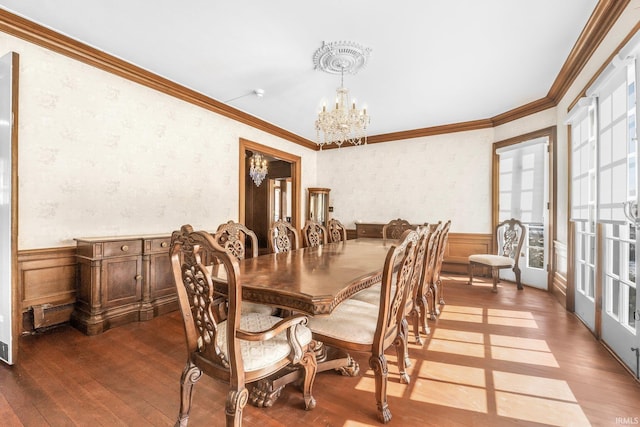 dining room with hardwood / wood-style floors, a notable chandelier, and ornamental molding