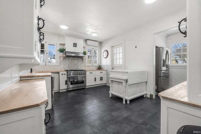 kitchen with white cabinets, decorative backsplash, stainless steel appliances, and a wall mounted air conditioner