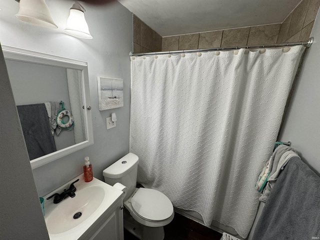 bathroom with curtained shower, vanity, and toilet