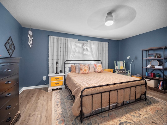 bedroom featuring a textured ceiling, hardwood / wood-style flooring, and ceiling fan