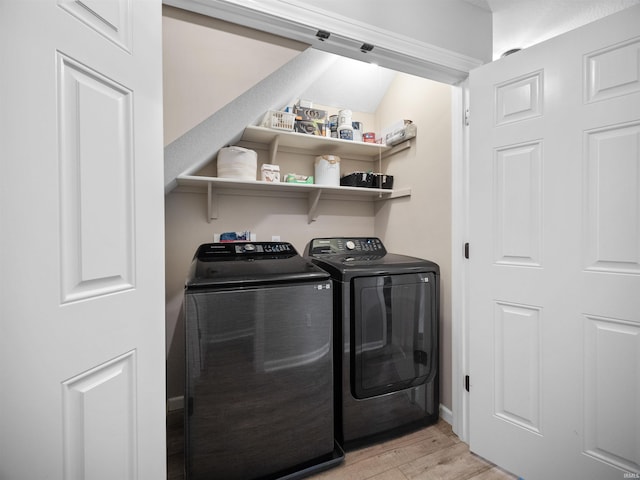 laundry area with washer and dryer and light wood-type flooring