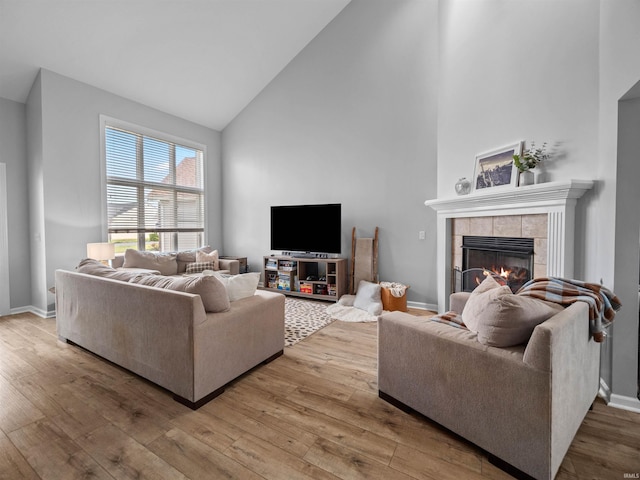 living room featuring a fireplace, hardwood / wood-style flooring, and high vaulted ceiling