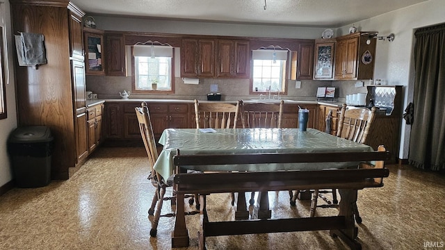 kitchen with a textured ceiling, backsplash, and a healthy amount of sunlight