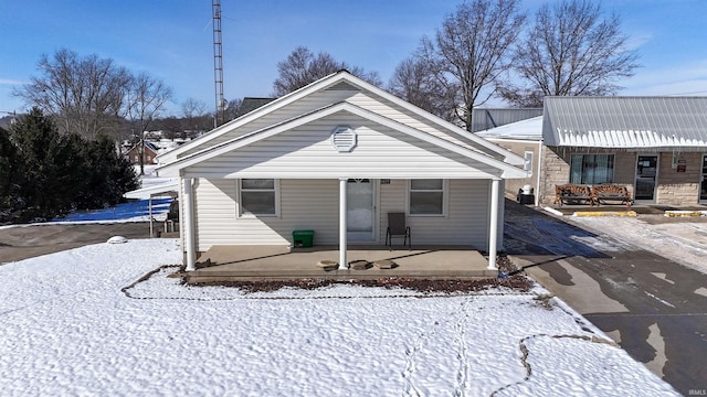 snow covered property with a porch