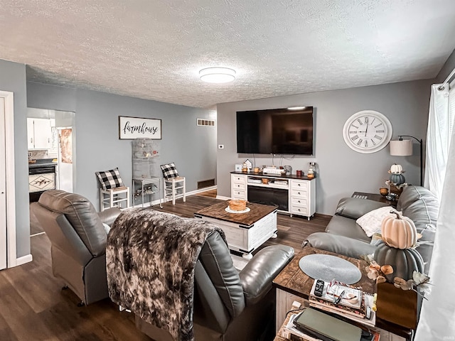 living room featuring dark hardwood / wood-style flooring and a textured ceiling