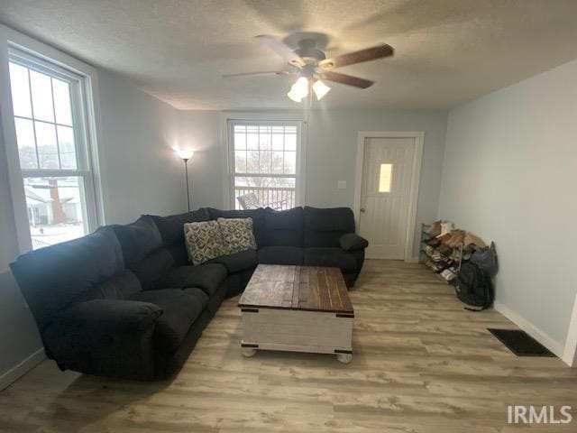 living room featuring ceiling fan and light hardwood / wood-style floors