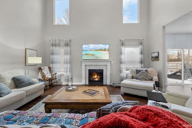 living room with dark wood-type flooring and a towering ceiling