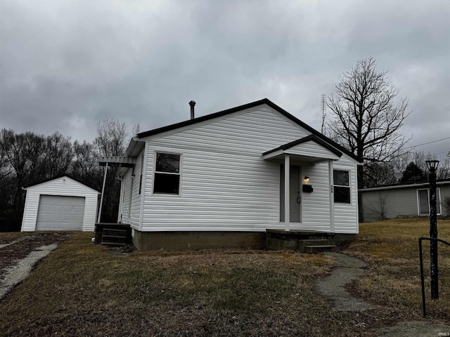 view of front facade featuring a garage, a front yard, and an outdoor structure