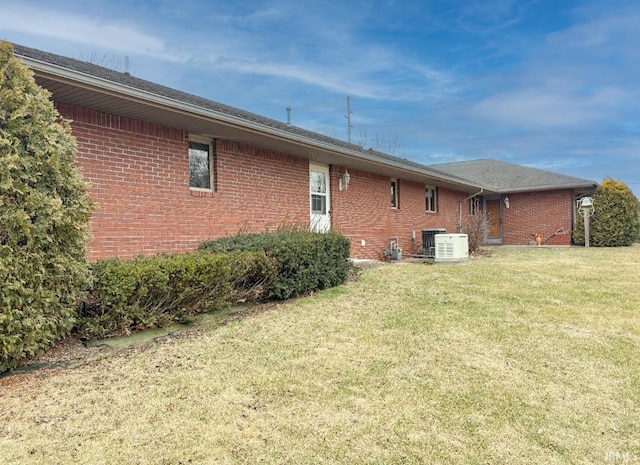 view of home's exterior with central AC unit and a lawn