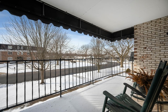 view of snow covered back of property