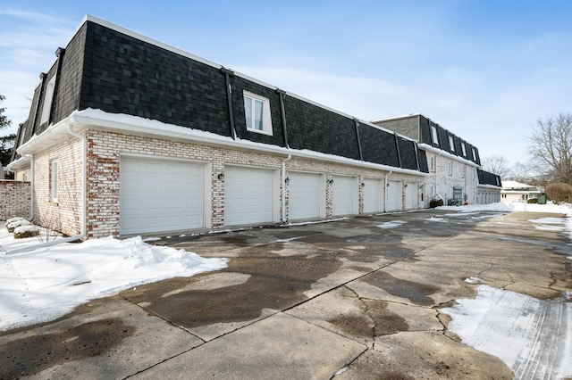 view of snow covered exterior with a garage