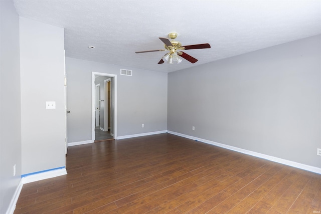 unfurnished room featuring dark hardwood / wood-style flooring, ceiling fan, and a textured ceiling