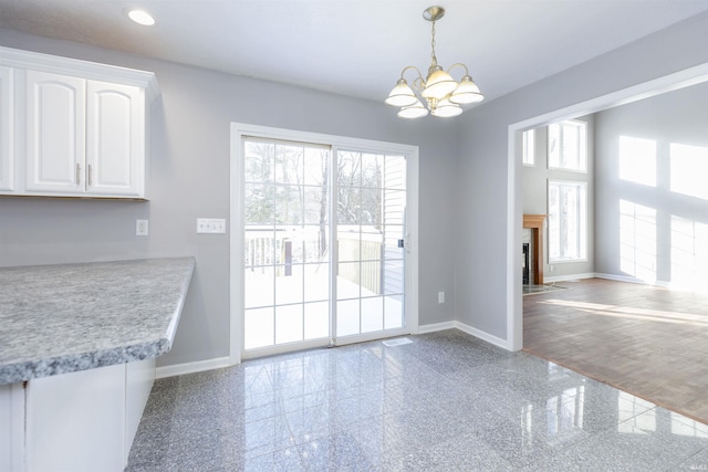 unfurnished dining area featuring a notable chandelier and a wealth of natural light