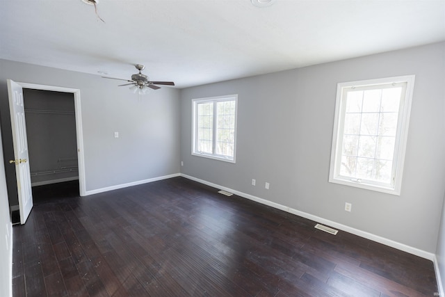 unfurnished room with ceiling fan and dark hardwood / wood-style flooring