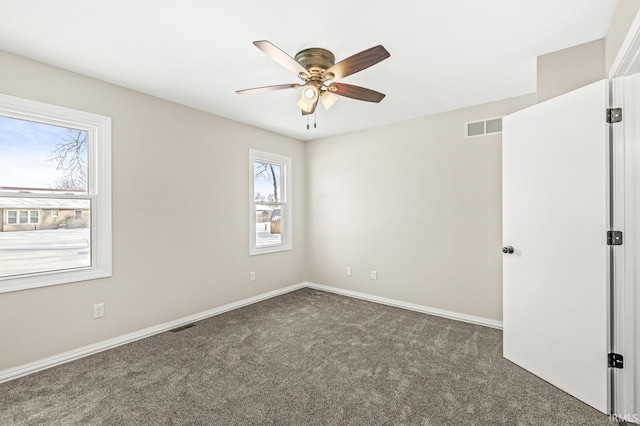 carpeted spare room featuring ceiling fan