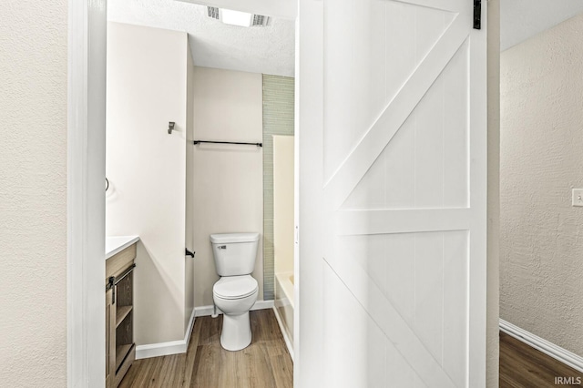 bathroom featuring vanity, toilet, a textured ceiling, and hardwood / wood-style floors