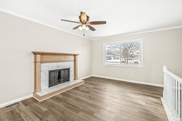 unfurnished living room with a fireplace, ornamental molding, hardwood / wood-style floors, and ceiling fan