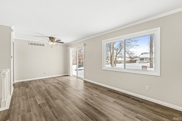 spare room featuring hardwood / wood-style flooring, ornamental molding, and ceiling fan